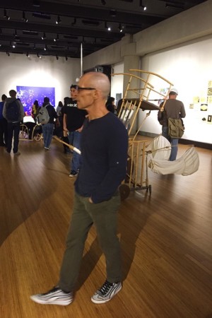 Professor Wayne Hulgin walks through the gallery with his beginning drawing class one night before the opening of the current mixed media exhibition. (Photo by Lupe Diaz)